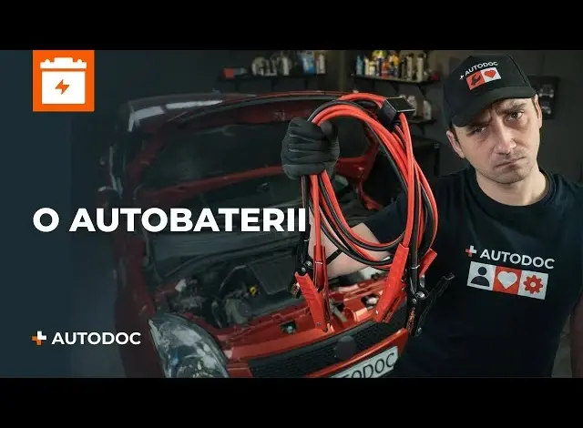 Muž drží červené kabely pro startování baterie u otevřeného motoru Mazdy.