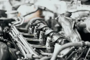 Detailní pohled na vnitřnosti automobilového motoru s viditelnými ventily a pružinami.