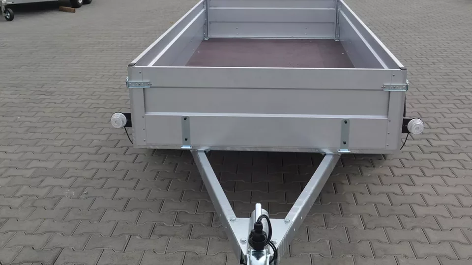 Stříbrný přívěs pro motoblok na dlažbě.