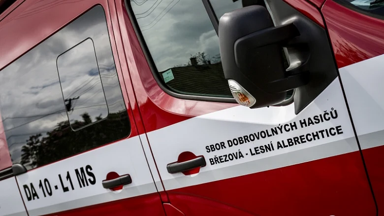 Červený hasičský vůz s nápisem sbor dobrovolných hasičů