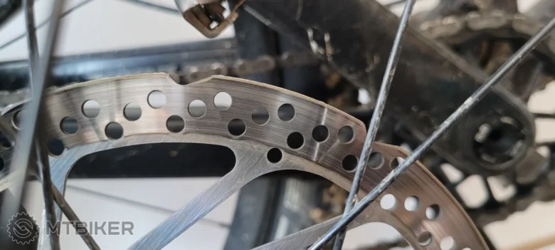 Detailní záběr na brzdový kotouč kola s otvory pro větrání.