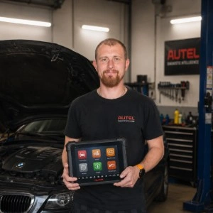 Mechanik s diagnostickým přístrojem v dílně u auta.