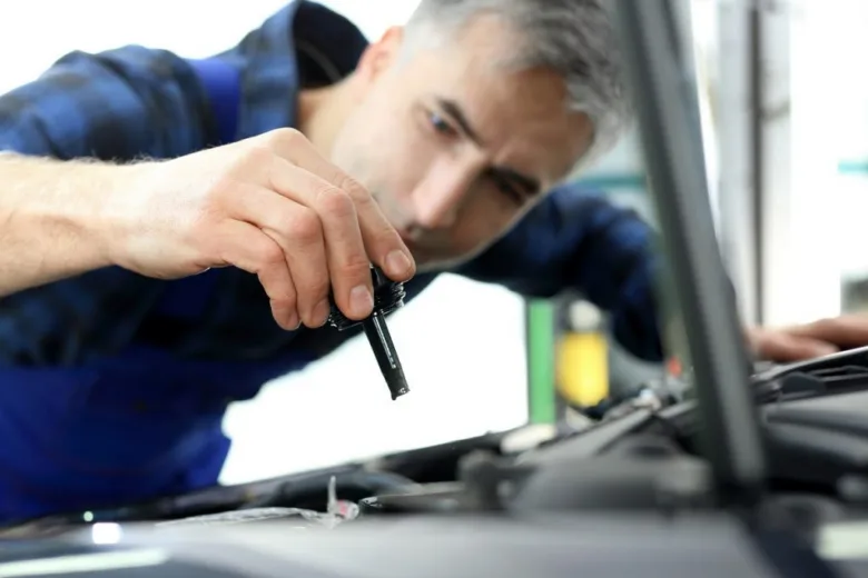 Mechanik kontroluje motor vozu při diagnostice problémů s řízením