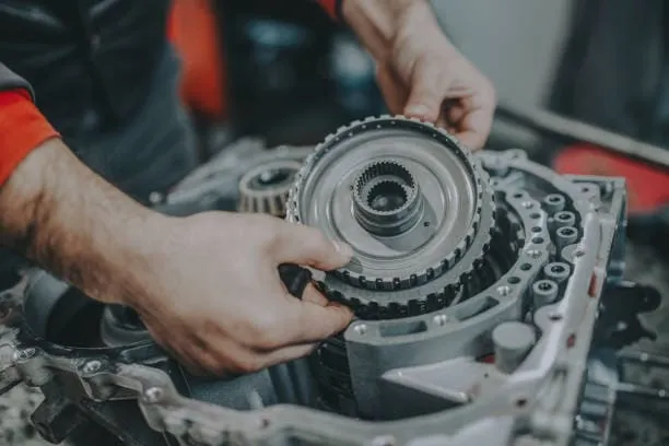 Mechanik montuje řemenový hřídel do motoru při opravě.