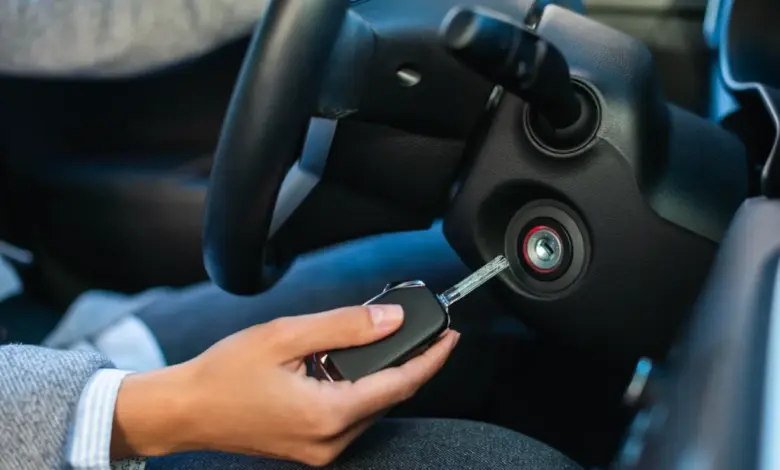 Ruka vkládá klíč do zapalovače automobilu u volantu.