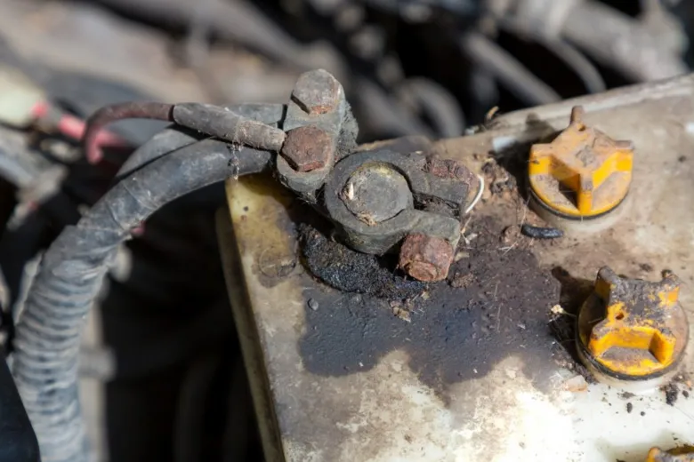 Zrezivělé kontakty autobaterie s oxidací na svorkách.