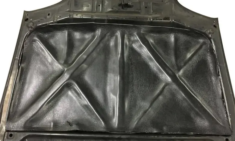 Černá akustická izolační fólie nalepená na vnitřní stranu kapoty automobilu.