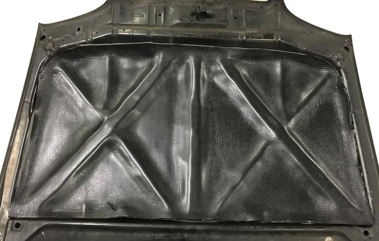 Černá akustická izolační fólie nalepená na vnitřní stranu kapoty automobilu.