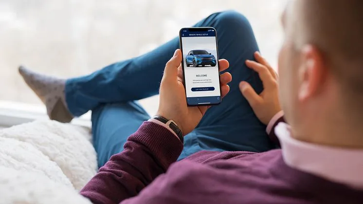 Muž používá aplikaci pro systém SYNC v autě na svém mobilu.