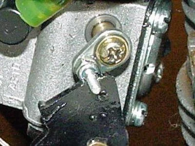 Detailní pohled na mechanismus spojení škrticí klapky karburátoru.