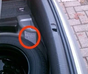 Štítek s kódem barvy vozu v kufru Audi.