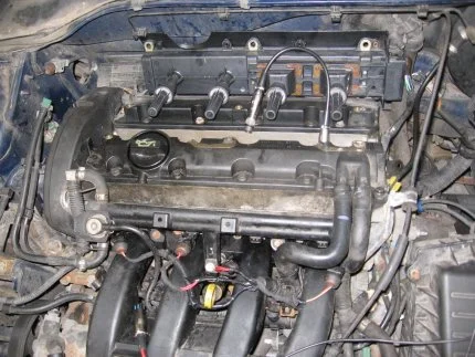 Motor automobilu s viditelnými komponenty pro diagnostiku komprese.