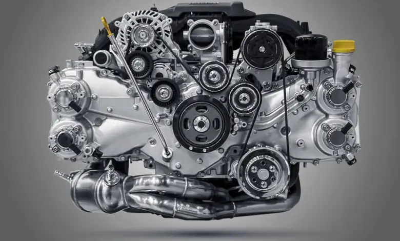 Detailní fotografie automobilového motoru s řemeny, ventilátorem a chladicími systémy.
