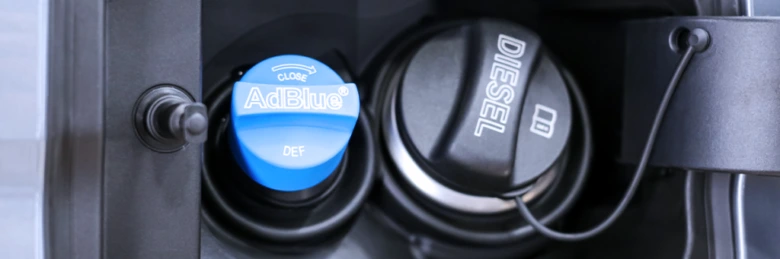 Modrá víčko s nápisem AdBlue vedle černéhoDiesel palivového hrdla.
