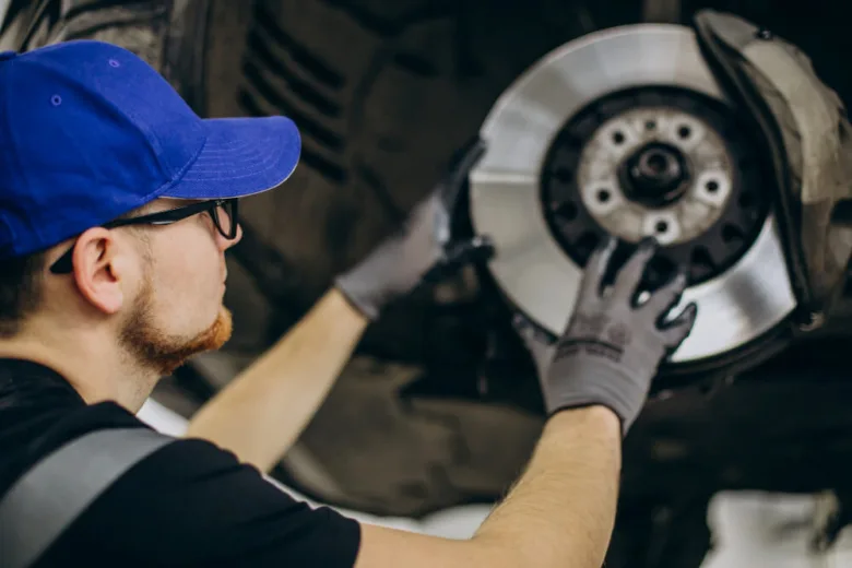 Mechanik opravuje brzdný disk u automobilu s ABS systémem.