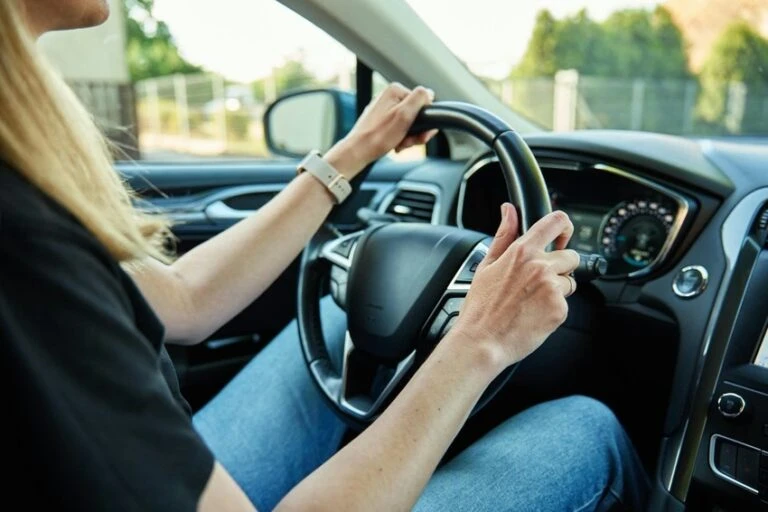 Žena řídí automobil v interiéru vozu.