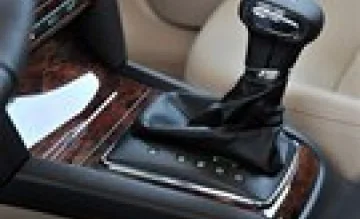 Automatická převodovka v interiéru automobilu s dřevěným dekorem.
