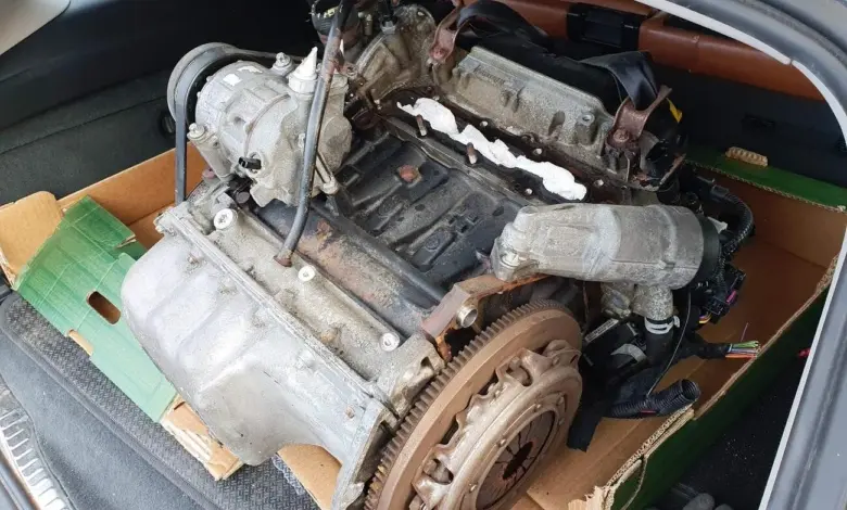 Vyňatý automobilový motor s převodovkou v krabici pro výměnu.