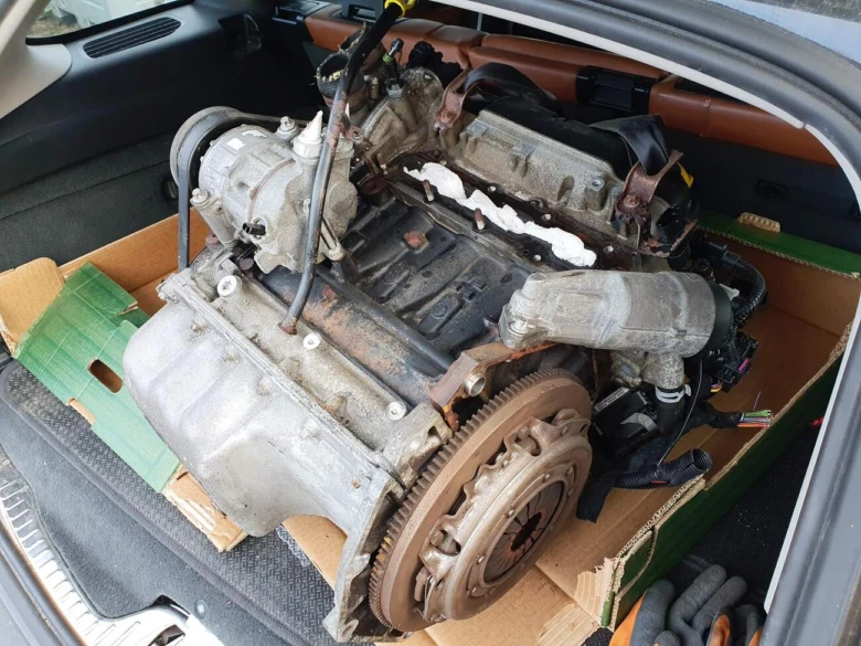 Vyňatý automobilový motor s převodovkou v krabici pro výměnu.