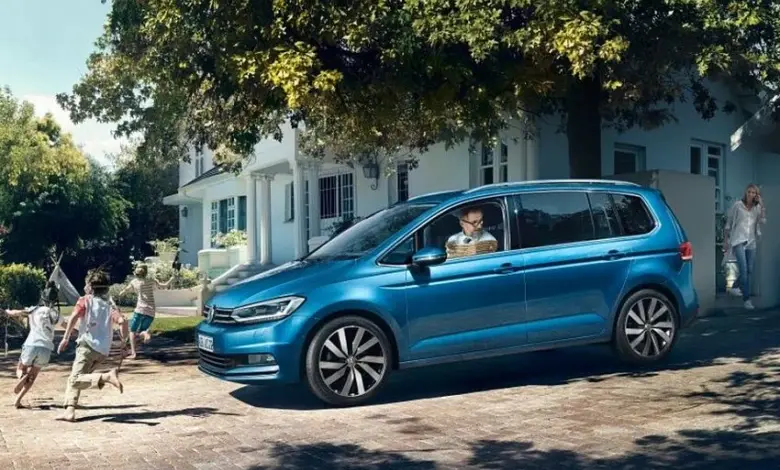 Modrý minivan s rodinou v pozadí na dvorku