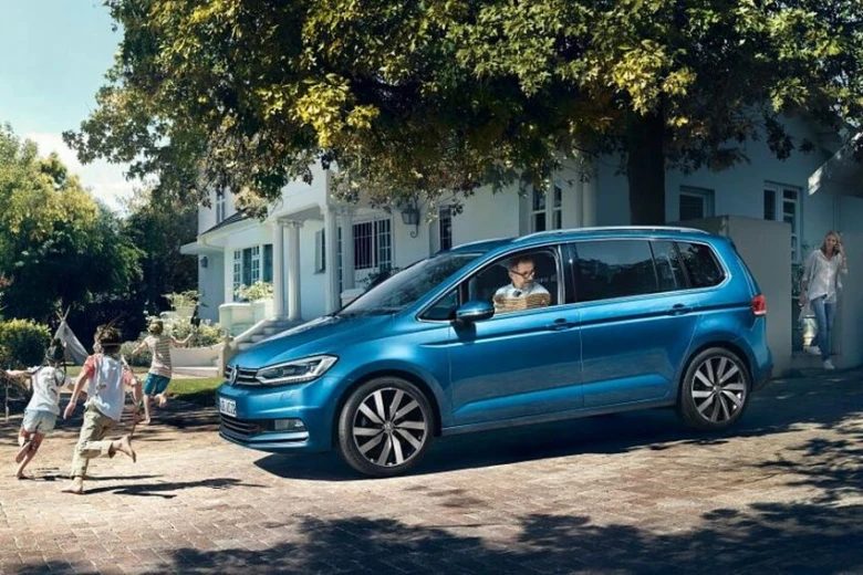 Modrý minivan s rodinou v pozadí na dvorku