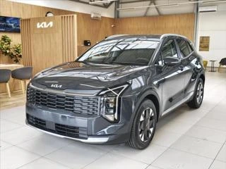 Šedý SUV Kia Sportage v interiéru prodejny.
