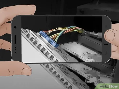 Smartphone zobrazuje schéma zapojení autorádia s barevnými vodiči.