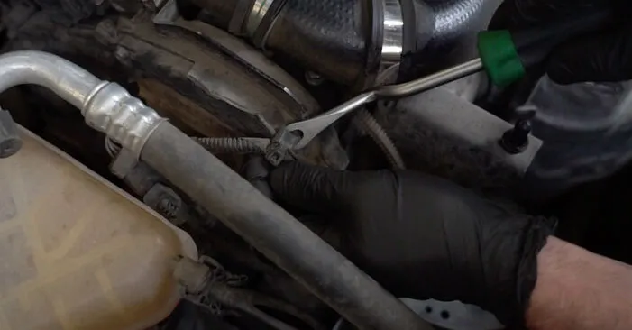 Mechanik demontuje součásti pro výměnu rozvodového řemene u Ford Focus.