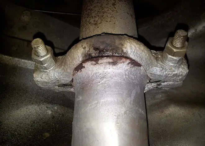 Rusty nerezový svorka na výfuku automobilu.
