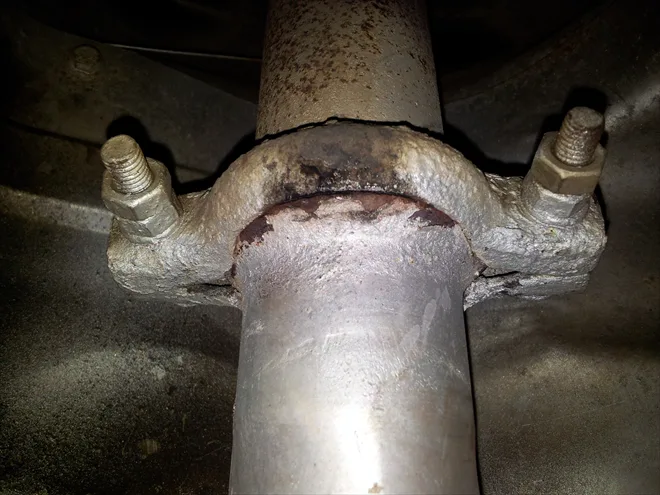 Rusty nerezový svorka na výfuku automobilu.