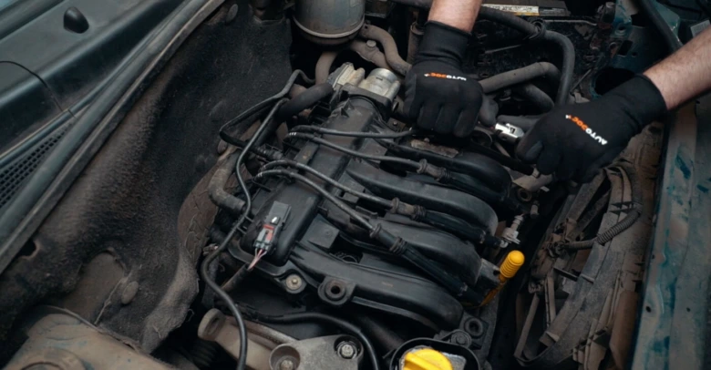 Ruční práce na motoru při údržbě zapalovacího systému.