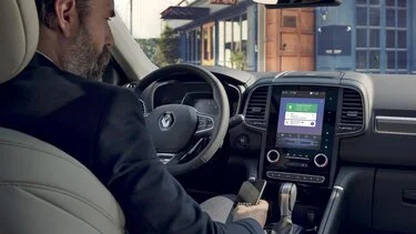 Muž řídí auto s aktivní mapou v integrované navigaci.