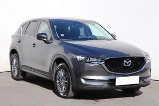 Šedý automobil Mazda CX-5 zobrazený na bílém pozadí.