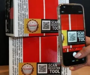 Mobilní telefon skenuje QR kód na krabici zapalovací svíčky značky NGK.