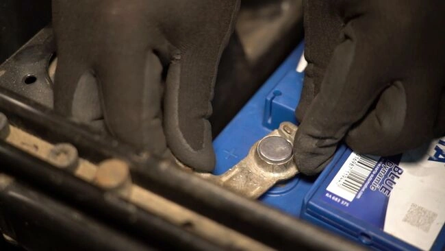 Ruční připojení kladného pólu autobaterie v motorovém prostoru.