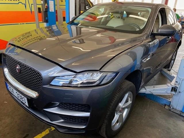 Poškozený přední nárazník vozu v autoservisu čekající na výměnu.
