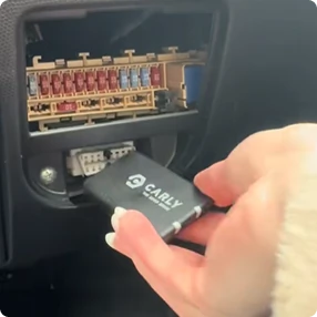 Ruční instalace diagnostického skeneru do zásuvky pod prkénkem.