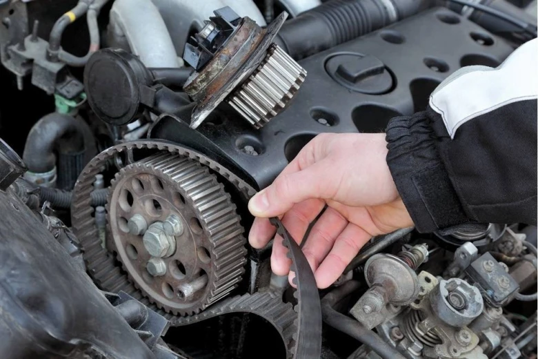 Mechanik opravuje rozvodový řemen u motoru vozu Peugeot nebo Citroën.