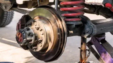 Detail bubnových brzd s viditelným opotřebením a pružinou u vozidla.
