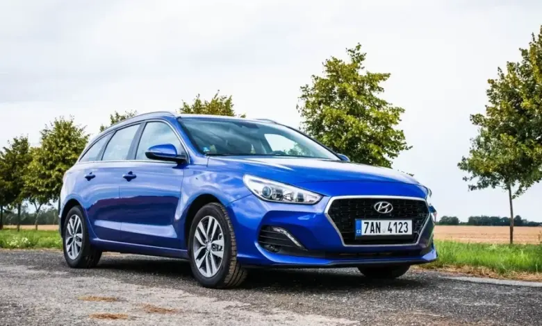 Modrý vůz Hyundai i30 na venkovské cestě mezi stromy.
