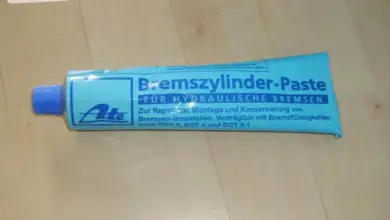 Tubka s pastou pro mazání brzdových válců na dřevěném povrchu.
