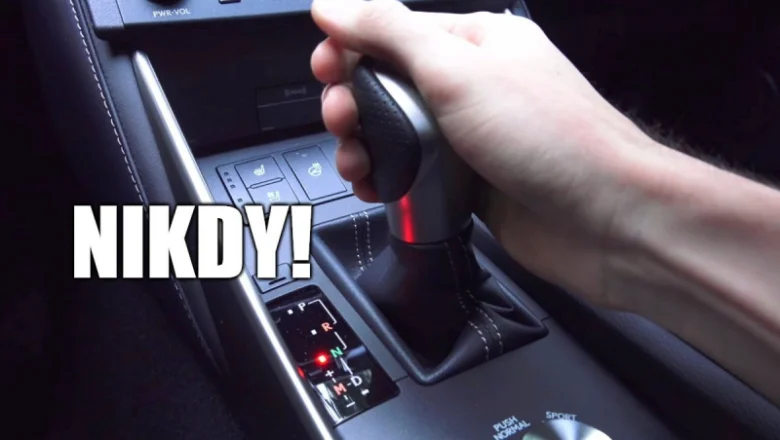 Ruka na páce převodovky v automobilu s automatikem.