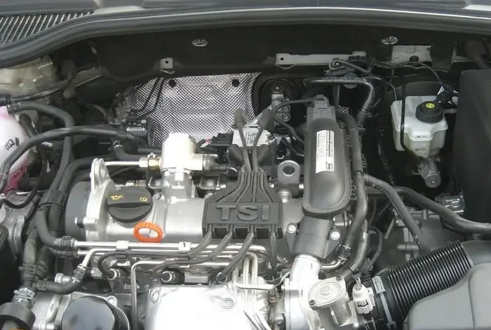 Motorizace s označením TSI v otevřené kapotě automobilu.