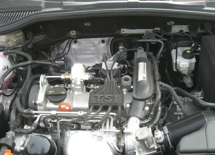 Motorizace s označením TSI v otevřené kapotě automobilu.