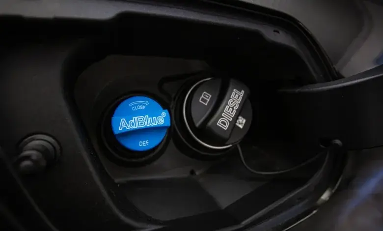 Modrá víčko s nápisem AdBlue vedle černého Diesel víčka.