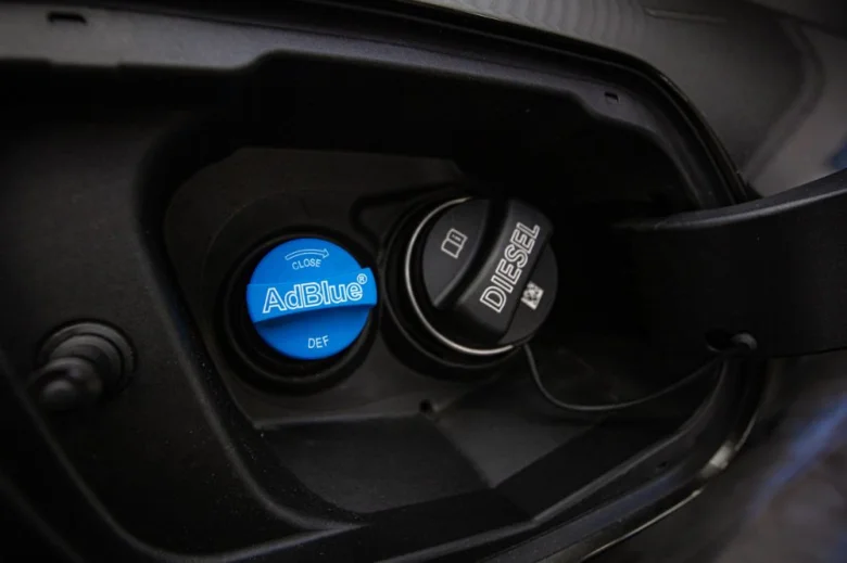 Modrá víčko s nápisem AdBlue vedle černého Diesel víčka.