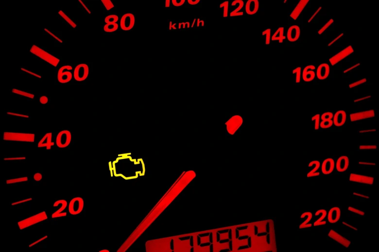 Žlutá kontrolka motoru na přístrojové desce auta.