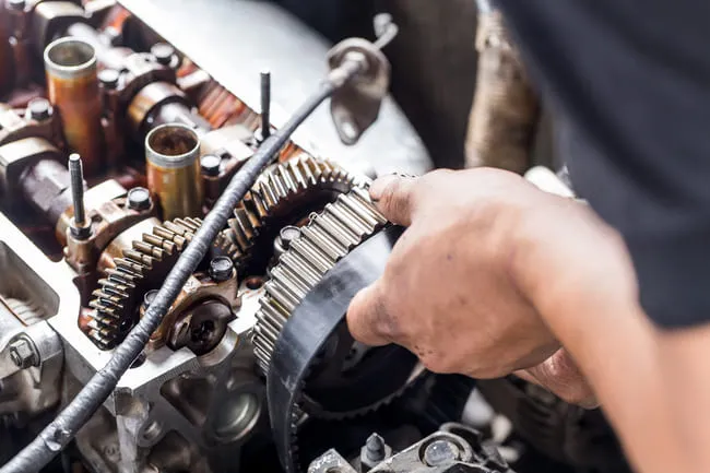 Mechanik opravuje řemenový rozvod motoru Peugeot.