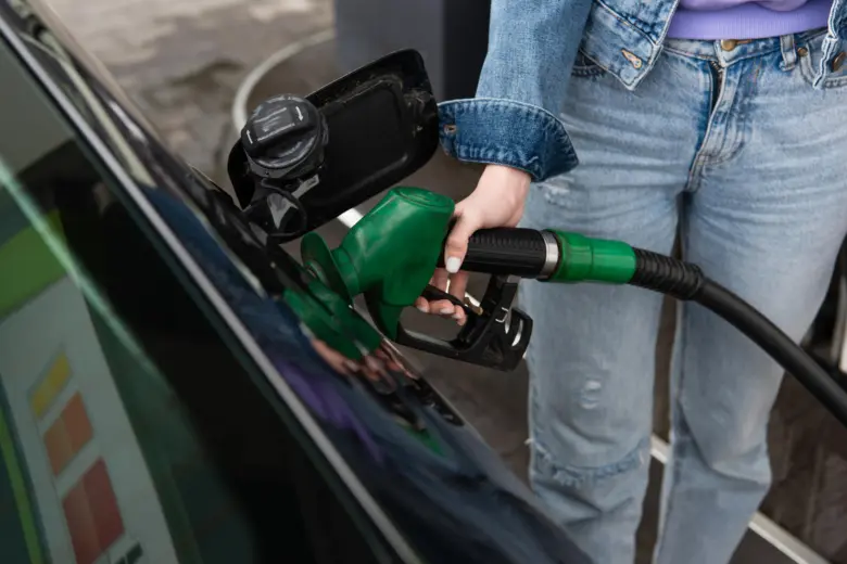 Člověk doplňuje palivo do auta zelenou čerpadlem na benzínové stanici.