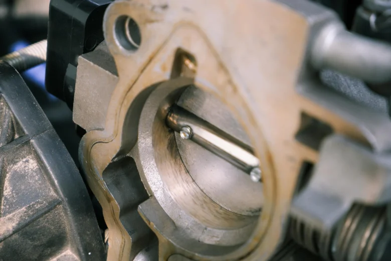 Detailní pohled na škrticí klapku v motoru automobilu.